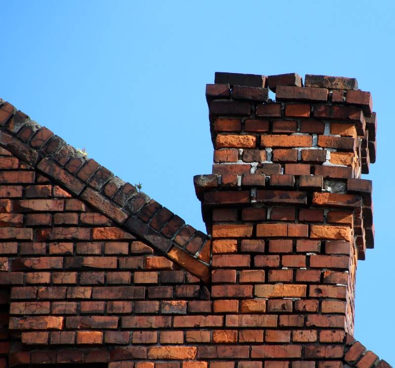 Damaged chimney on an Camp Springs home showing cracks and missing mortar